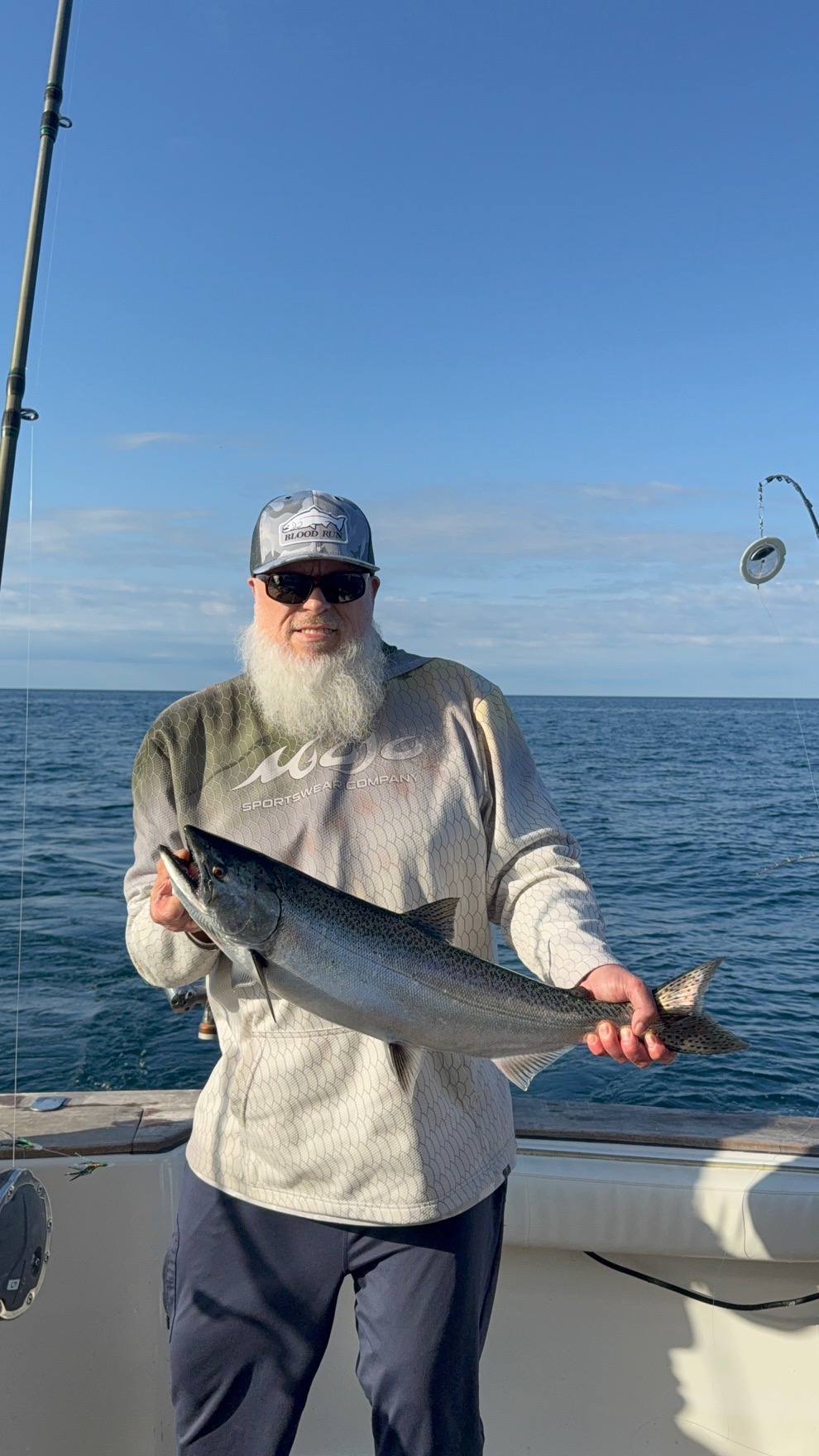 Dad holding a salmon on Lake Michigan under a clear sky, Frankfort trip August 28, 2026